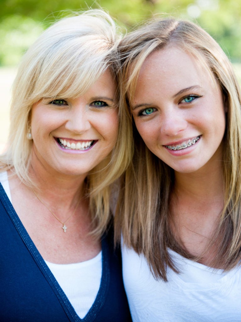 A mother and daughter smiling